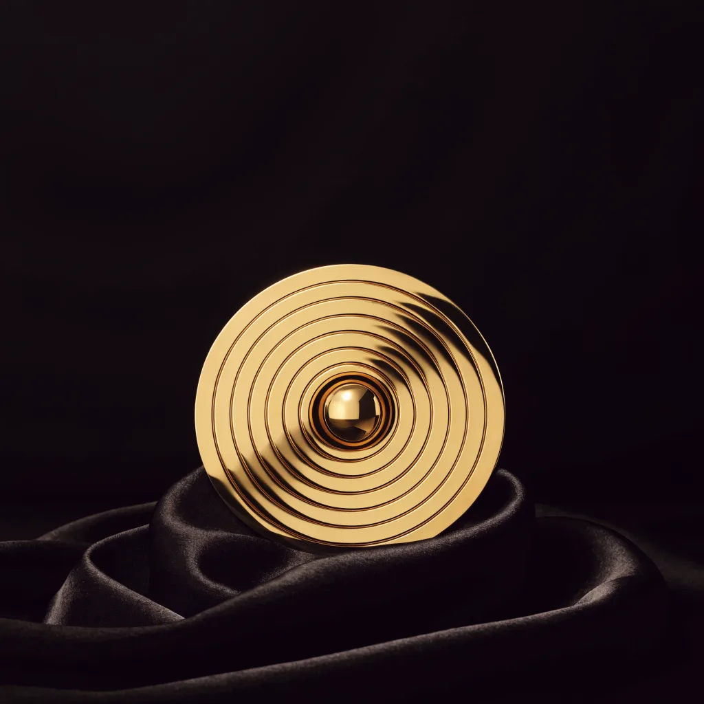 Concentric gold rings forming a target with a gold sphere at the center, on black silk